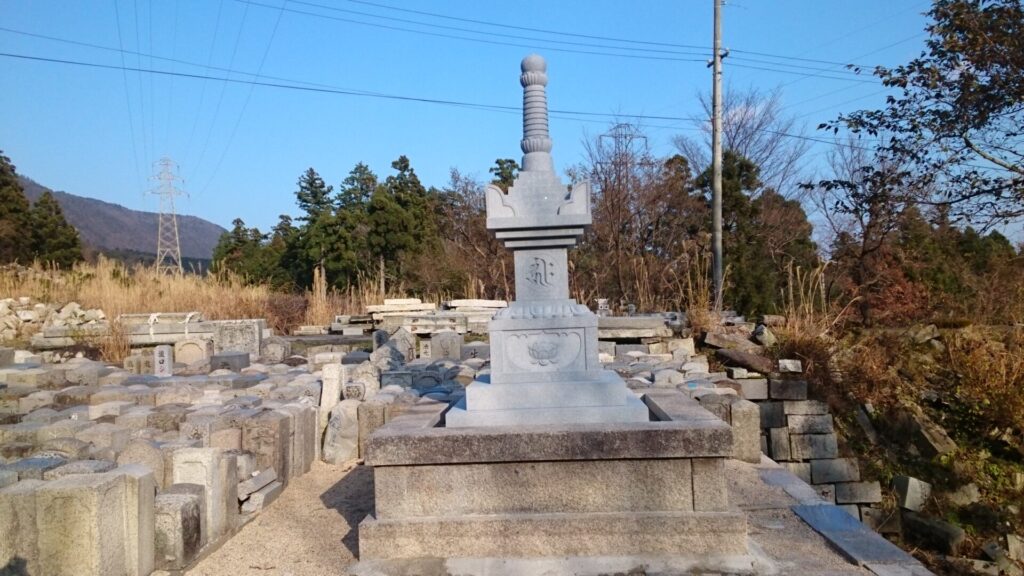 青御影石で作られた宝篋印塔の正面。格狭間には近江式文様の開蓮華が彫刻されている。